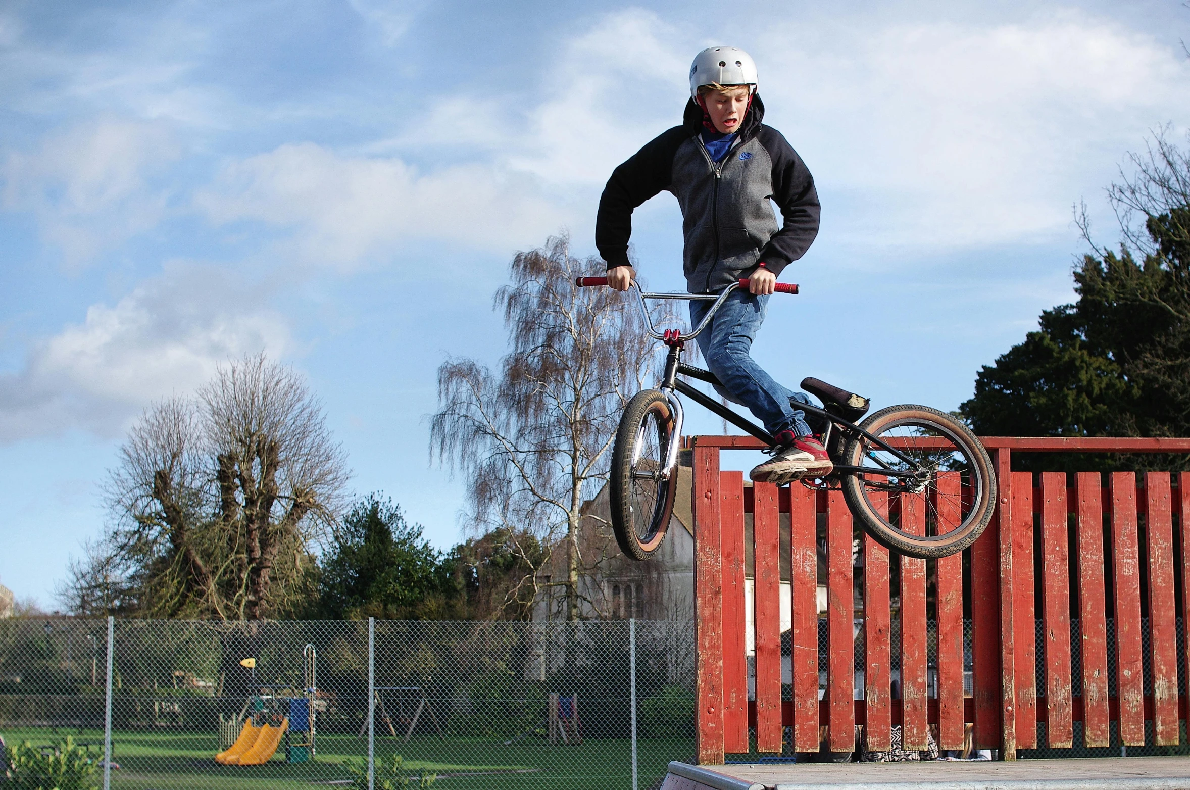 a man flying through the air while riding a bike, standing astride a gate, wooden platforms, heath clifford, regular build