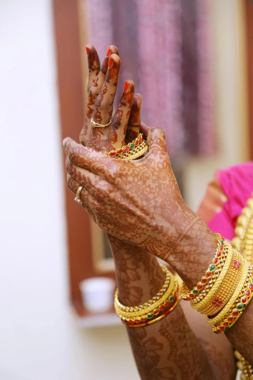 a woman with her hands in the air, an album cover, by Bholekar Srihari, wedding, brown, bracelets, low detail