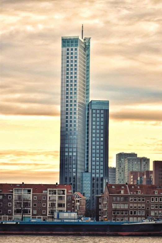 a large body of water with a city in the background, a picture, by Jan Tengnagel, gigantic tower, sunset!, square, flanders