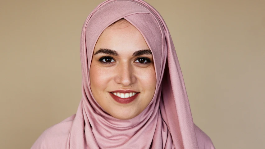 a close up of a person wearing a headscarf, plain background, light skin tone, mid length portrait photograph, she is 2 3