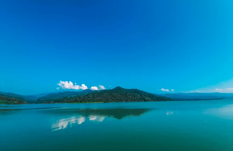 a large body of water with mountains in the background, inspired by Tadao Ando, pexels contest winner, sumatraism, cloudless sky, tropical island, hd wallpaper, guwahati