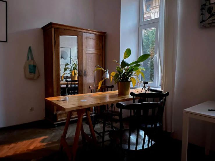 a wooden table sitting in a room next to a window, by Emma Andijewska, bar tosz domiczek, profile image, furnished room, khreschatyk