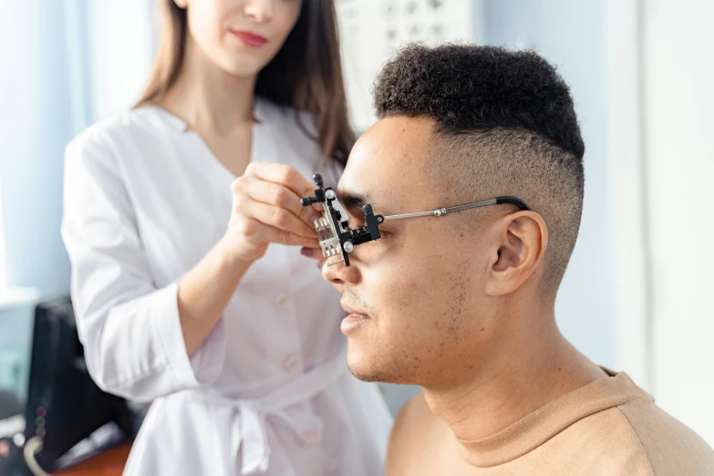 a man getting his hair cut by a woman, pexels contest winner, photorealism, wearing reading glasses, detailed: cornea, male physician, manuka