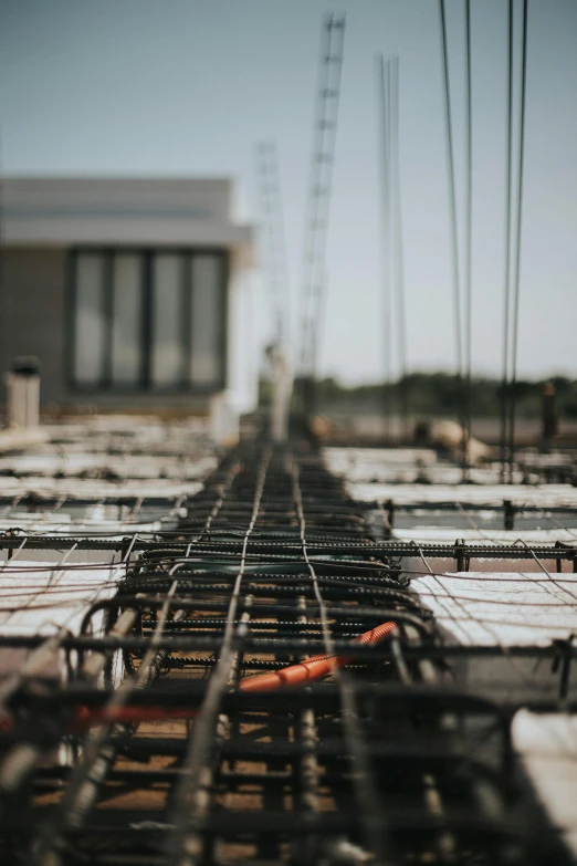 a bunch of steel rods sitting on top of a building, unsplash photography, multiple stories, machinery and wires, smooth concrete