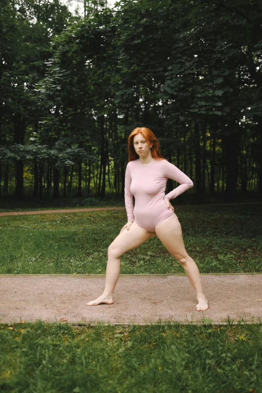 a woman that is standing in the grass, an album cover, inspired by Vanessa Beecroft, unsplash, renaissance, wearing leotard, a redheaded young woman, walking at the park, pink
