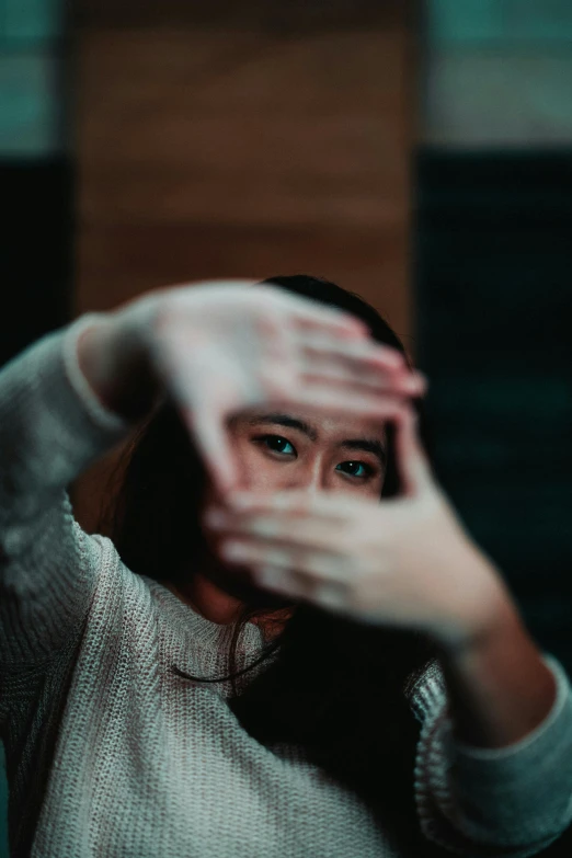 a woman making a stop sign with her hands, pexels contest winner, visual art, eyes looking at the camera, asian women, indoor picture, hands shielding face