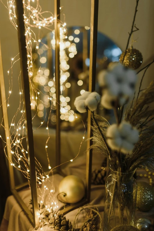 a vase filled with white flowers sitting on top of a table, string lights, emitting light ornaments, brightly lit room, tactile buttons and lights