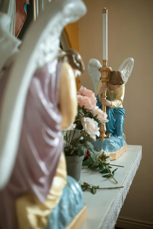 a couple of figurines sitting on top of a table, on the altar, angel themed, up close, slide show