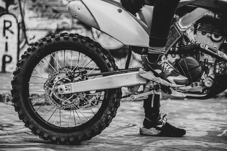 a black and white photo of a person sitting on a motorcycle, by Adam Marczyński, pexels contest winner, with gears and tubes, motocross bike, sneaker photo, closeup!!!!!!