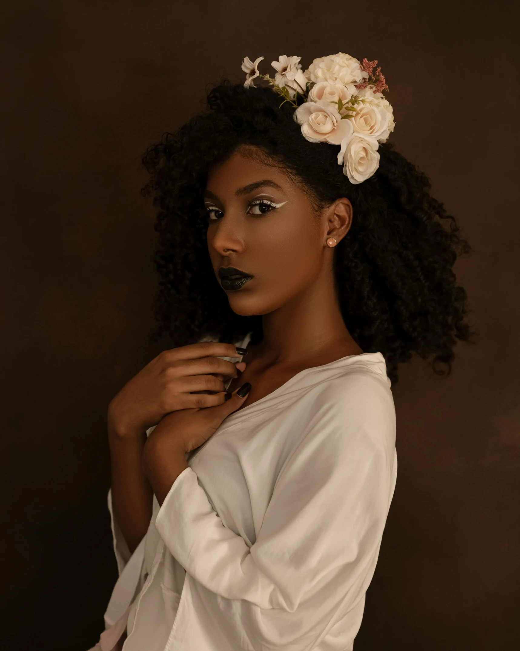 a woman with a flower in her hair, by Lily Delissa Joseph, trending on unsplash, afrofuturism, dark lipstick, white flower crown, studio photo, wearing a grey robe