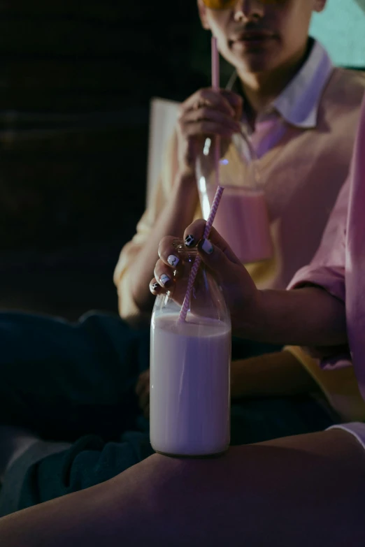 a woman sitting on a couch holding a bottle of milk, by Peter Alexander Hay, trending on pexels, hyperrealism, purple dim light, drink milkshakes together, night outside, **cinematic