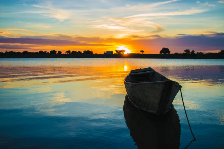 a boat sitting on top of a body of water, pexels contest winner, hurufiyya, colours of the sunset, lagoon, idyllic, youtube thumbnail