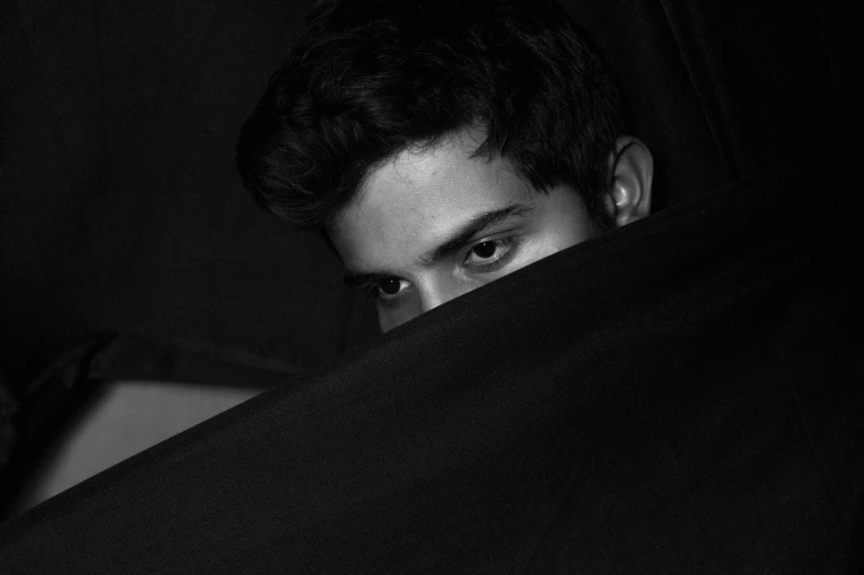 a black and white photo of a man hiding behind a blanket, by Alexis Grimou, jayison devadas, young male, roshan, staring!!!!! into the camera