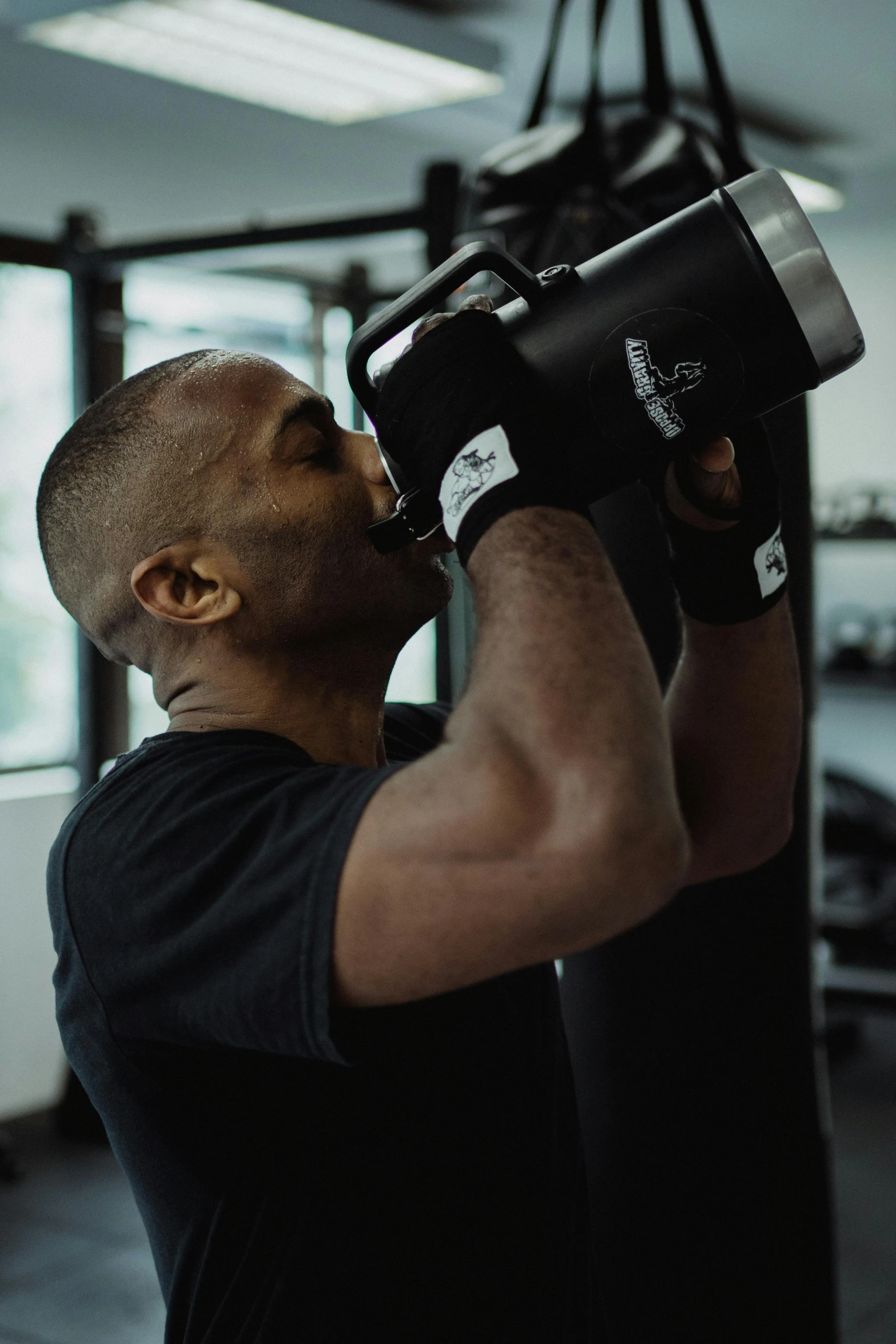 a man punching a punching bag in a gym, by Sam Charles, pexels contest winner, drink more coffee, black body, profile image, thumbnail