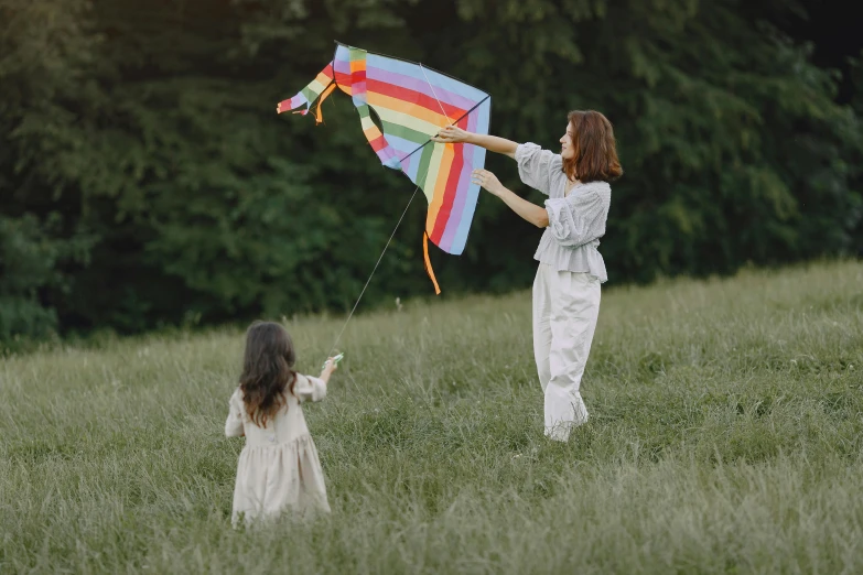 a woman and a little girl in a field flying a kite, pexels contest winner, color field, grey, avatar image, rainbow accents, casual game