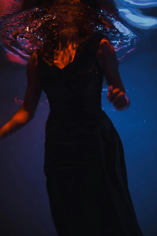 a woman in a black dress under water, unsplash, in a nightclub, half-turned lady in evening gown, mid view, portait image