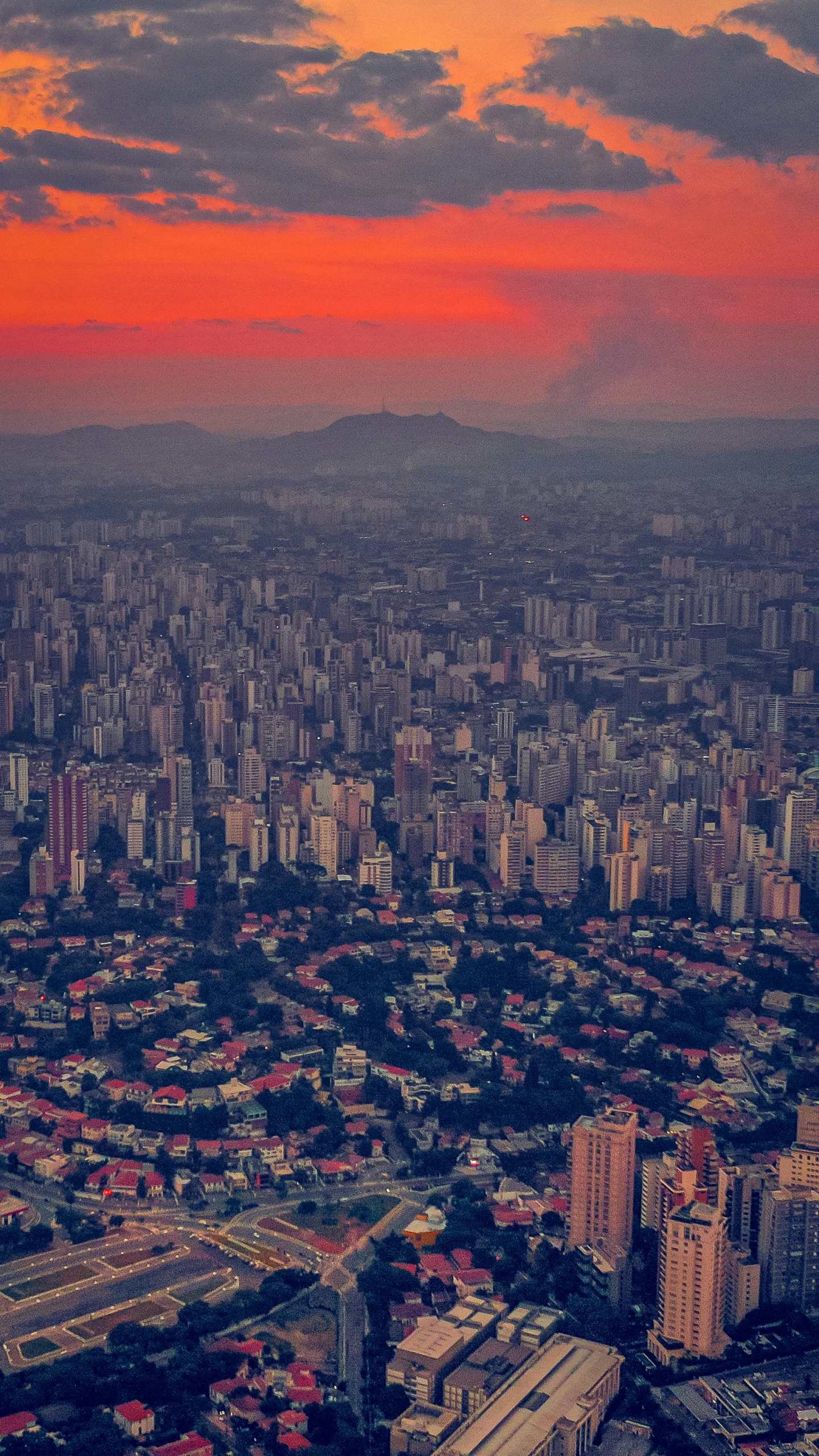 an aerial view of a city at sunset, by Elsa Bleda, pexels contest winner, colombian, red hues, grey, brazilian