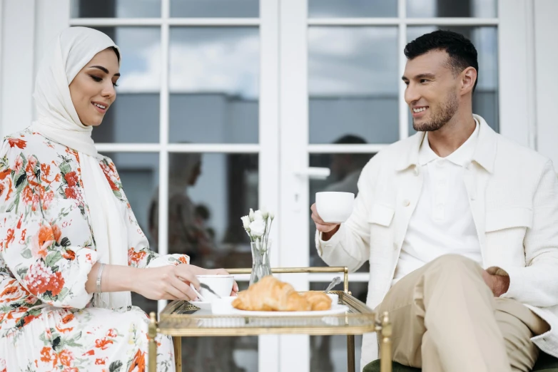 a man and a woman sitting at a table, trending on pexels, hurufiyya, white hijab, luxury and elite, milk and mocha style, caucasian