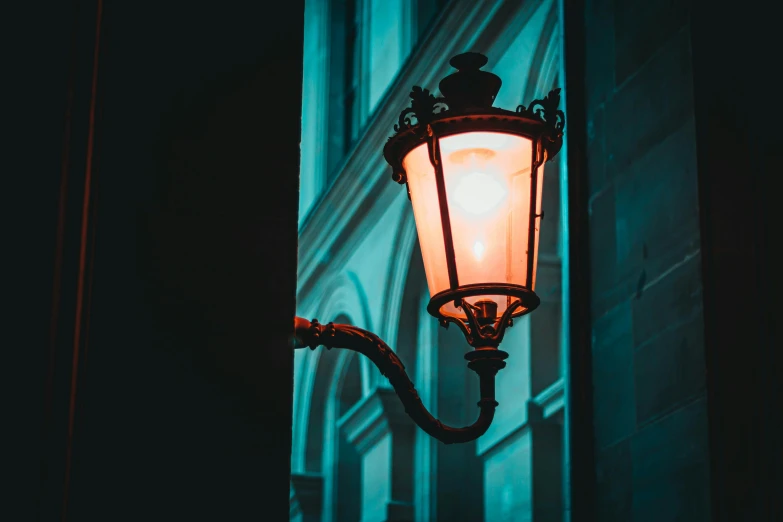 a light that is on the side of a building, inspired by Elsa Bleda, pexels contest winner, baroque, orange teal lighting, streetlamp, gothic lighting, dim blue light