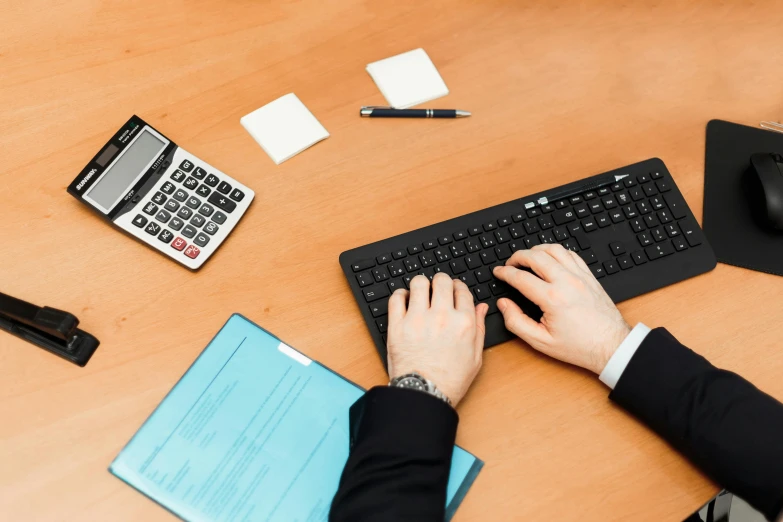 a man in a suit is typing on a keyboard, unsplash, hurufiyya, realistic »