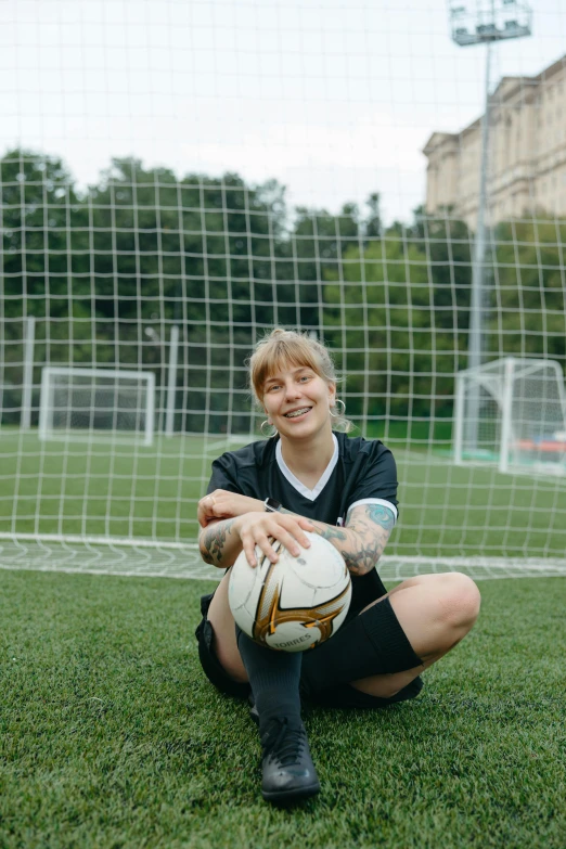 a man sitting on the ground with a soccer ball, short platinum hair tomboy, on a soccer field, portrait featured on unsplash, olga zakharova