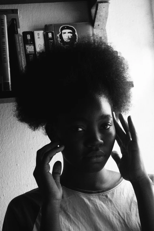 a black and white photo of a woman talking on a cell phone, a black and white photo, inspired by Carrie Mae Weems, pexels contest winner, afrofuturism, light skinned african young girl, hands in her hair, 🤤 girl portrait, pale white face