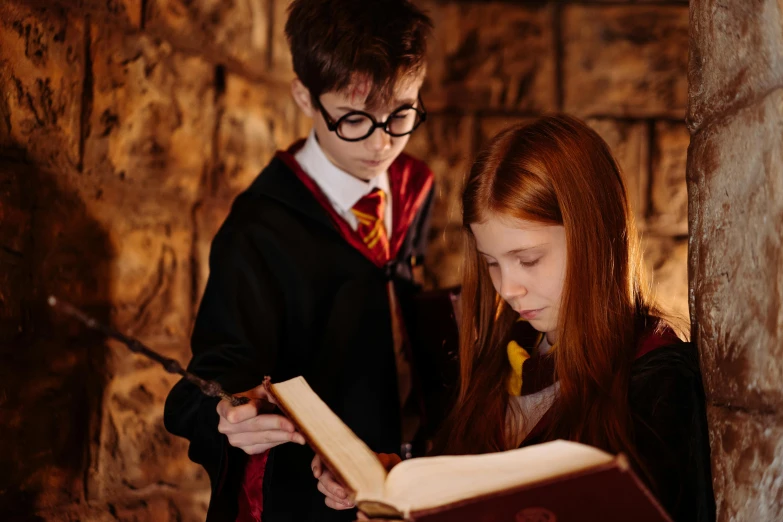 a couple of people that are looking at a book, a portrait, by Helen Stevenson, pexels contest winner, a young female wizard, magic school uniform, in an ancient vault, ron weasley