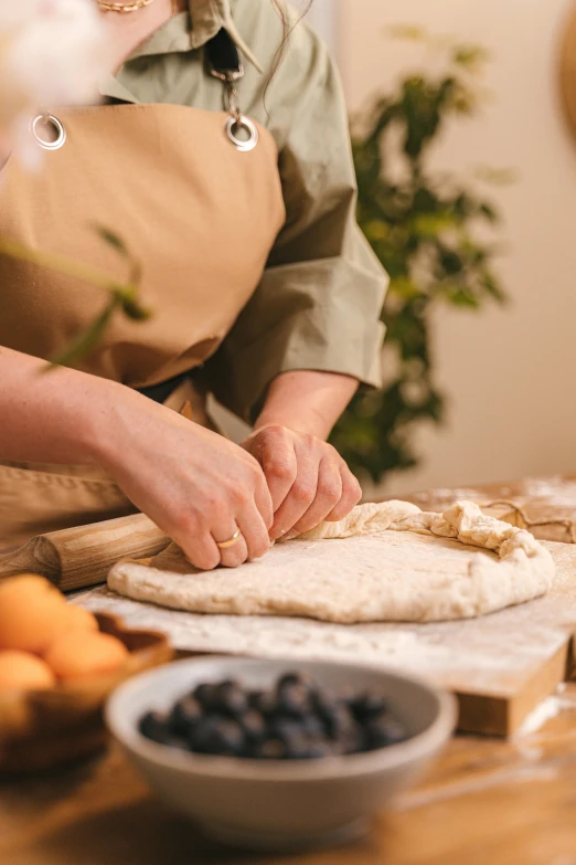 a woman in an apron preparing food on a table, a marble sculpture, inspired by Normand Baker, trending on pexels, loaves, linen, cooking pizza, banner