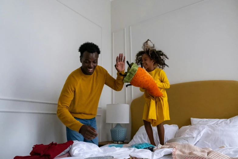 a man and a little girl standing on a bed, pexels contest winner, happening, yellow orange, excited, african american, cast