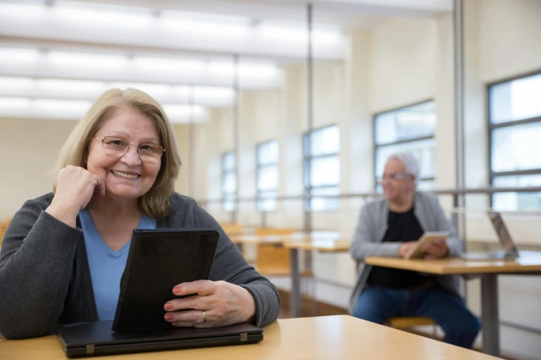 a woman sitting in front of a laptop computer, unsplash, academic art, 70 years old, avatar image, in a classroom, lachlan bailey