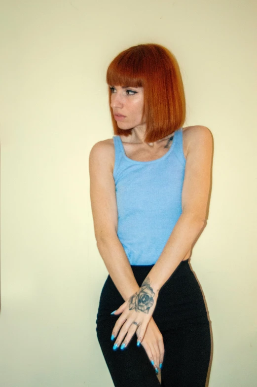 a woman in a blue shirt and black pants, an album cover, inspired by Elsa Bleda, featured on reddit, hyperrealism, red short hair, 🤤 girl portrait, late 1 9 6 0's, wearing : tanktop