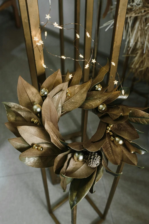 a close up of a wreath on a stand, a digital rendering, pexels, gold leaves, light brown, magnolia, upcycled