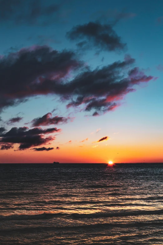 a large body of water with a sunset in the background, unsplash contest winner, romanticism, colorful clouds, 2019 trending photo, a photo of the ocean, portrait photo