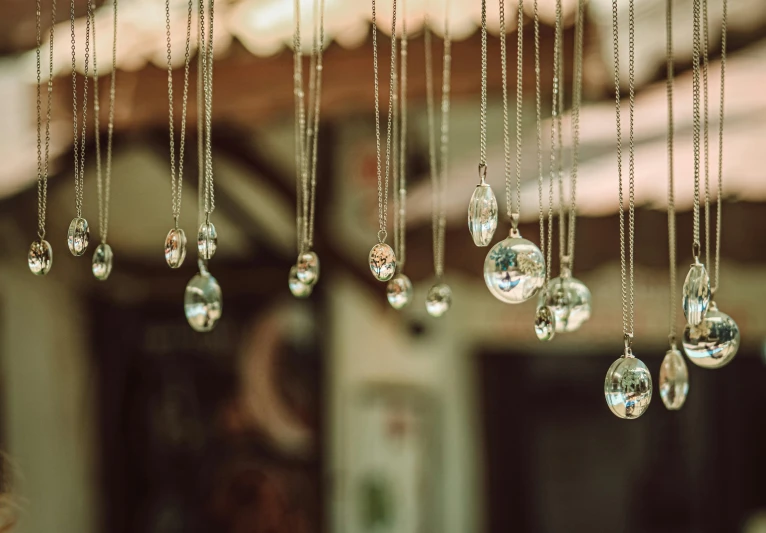 a bunch of crystal balls hanging from a ceiling, inspired by Elsa Bleda, trending on pexels, detailed jewelry, raining outside, instagram post, pendants
