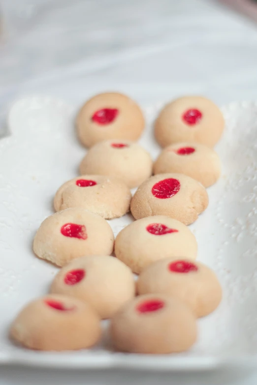 a white plate topped with cookies on top of a table, red round nose, gushy gills and blush, medium wide front shot, thumbprint