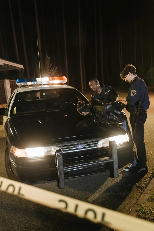 a police officer standing next to a police car, by Carey Morris, trending on unsplash, happening, still from movie, natgeo, awkward, mid night