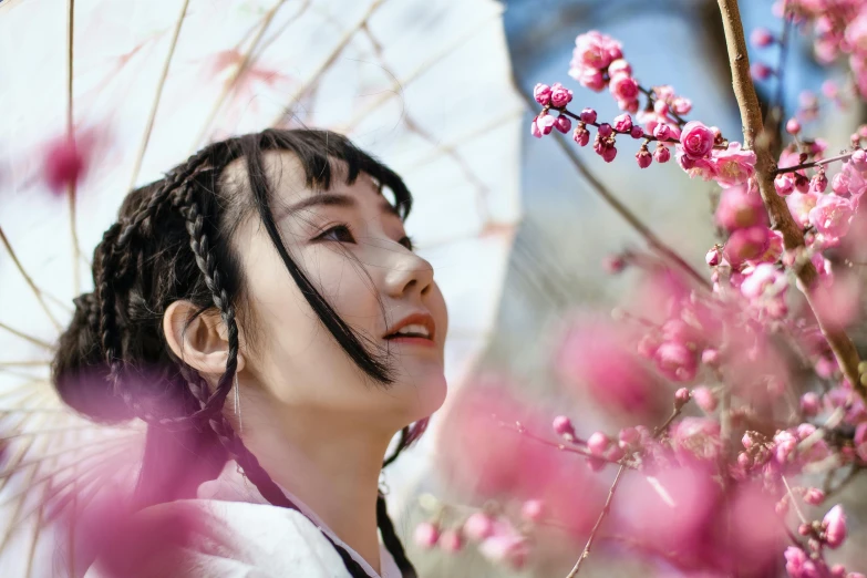 a woman standing in front of a tree with pink flowers, inspired by Itō Shinsui, pexels contest winner, pigtails hairstyle, chinese costume, avatar image, wuxia