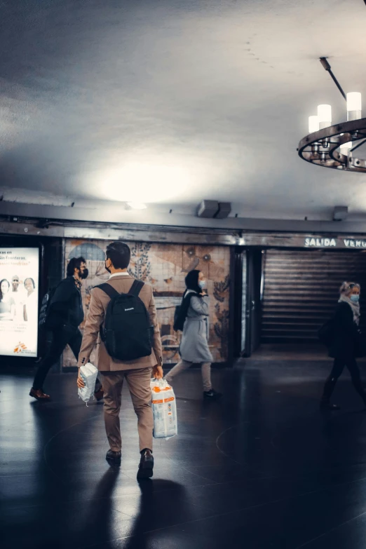 a group of people walking through a subway station, a poster, trending on unsplash, photo of a man, advertising lighting, marketplace, brown