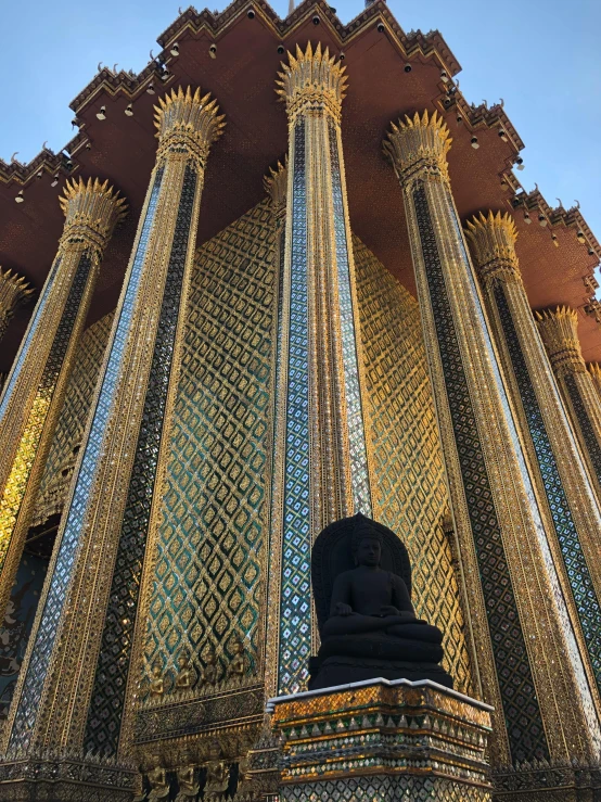 a tall building with a statue in front of it, golden pillars, massive wide trunk, instagram picture, thai