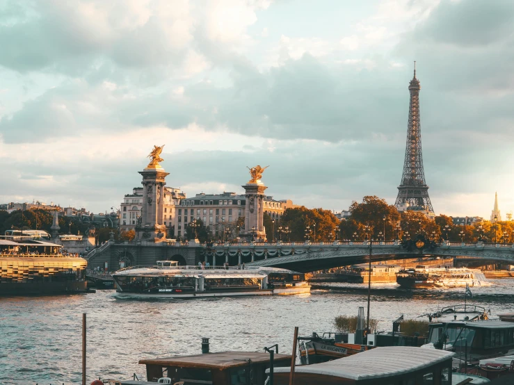 a view of the eiffel tower from across the river, a photo, pexels contest winner, boats in the water, thumbnail, brown, subtitles