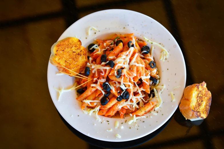 a white plate topped with pasta and black olives, pexels contest winner, orange red black white, daily specials, thumbnail, panini