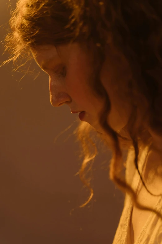 a close up of a person using a cell phone, inspired by Nan Goldin, renaissance, flowing backlit hair, 8 k film still, pensive, curly bangs