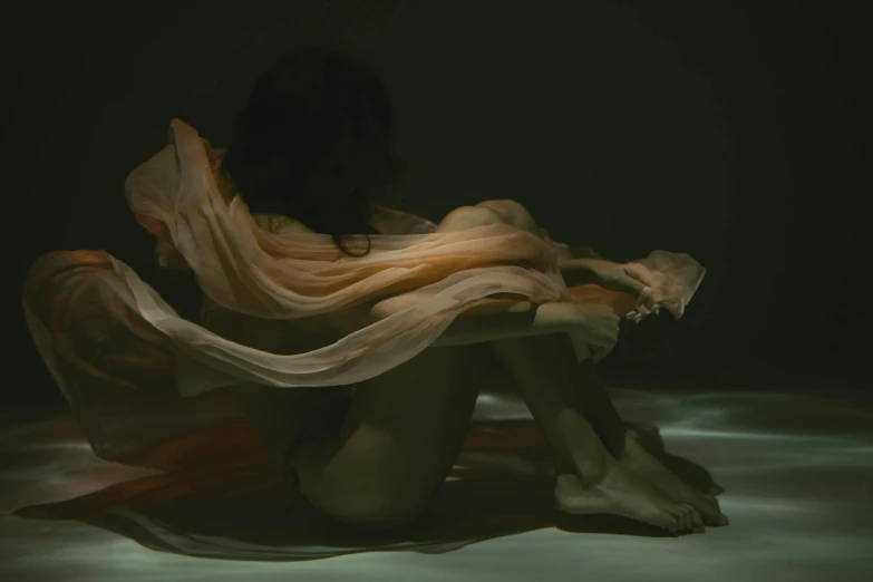 a woman that is sitting down in the dark, an album cover, inspired by Elsa Bleda, pexels contest winner, figurative art, flowing salmon-colored silk, wearing translucent sheet, showstudio, bodyless