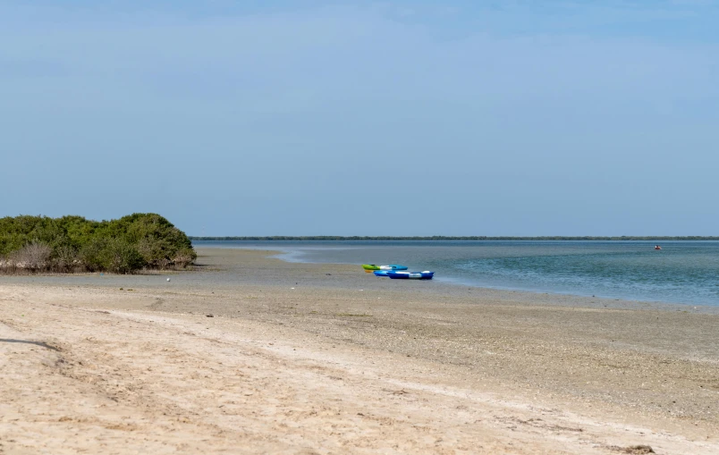 a couple of boats sitting on top of a sandy beach, hurufiyya, lagoon, image, taken with canon 5d mk4, sun coast