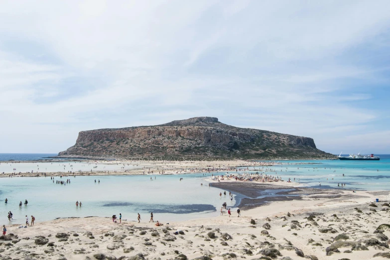 a group of people standing on top of a sandy beach, chris achilleos, an island, view from the sea, flatlay