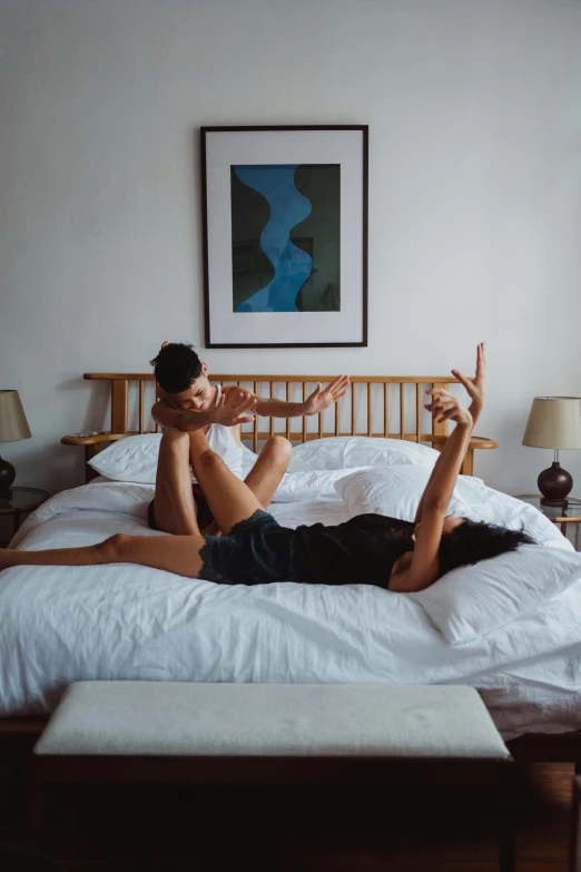 a woman laying on a bed with her legs up, unsplash, visual art, couple dancing, holding each other, gif, arms out