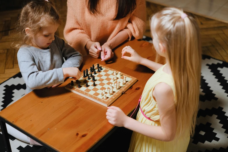 a woman and two children playing a game of chess, pexels contest winner, on a wooden table, 15081959 21121991 01012000 4k, decoration, thumbnail