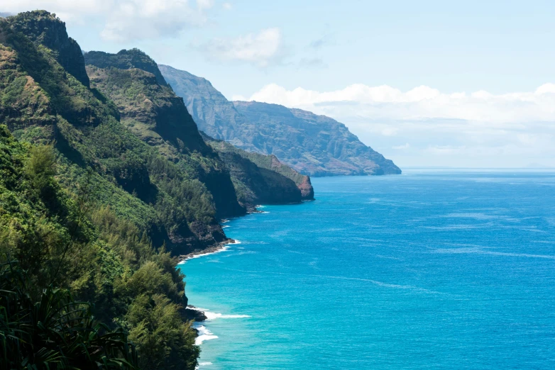 a view of the ocean from the top of a mountain, a photo, kauai, avatar image, teal aesthetic, trees and cliffs