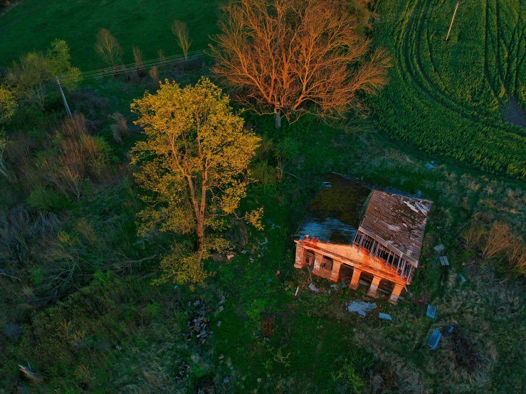 a house sitting on top of a lush green field, an album cover, by Filip Hodas, pexels contest winner, renaissance, wide high angle view, evening light, abandoned cottage, detailed photo 8 k