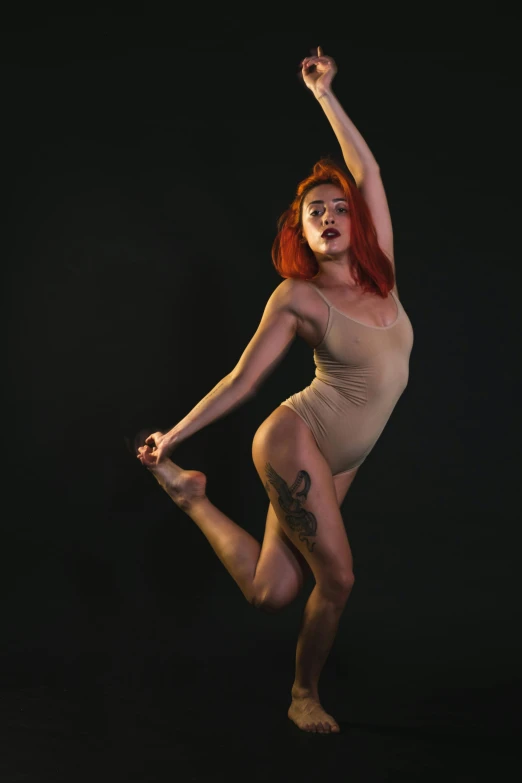 a woman with red hair jumping in the air, an album cover, inspired by Elizabeth Polunin, unsplash, on a mannequin. studio lighting, wearing leotard, intimidating pose, low quality photo